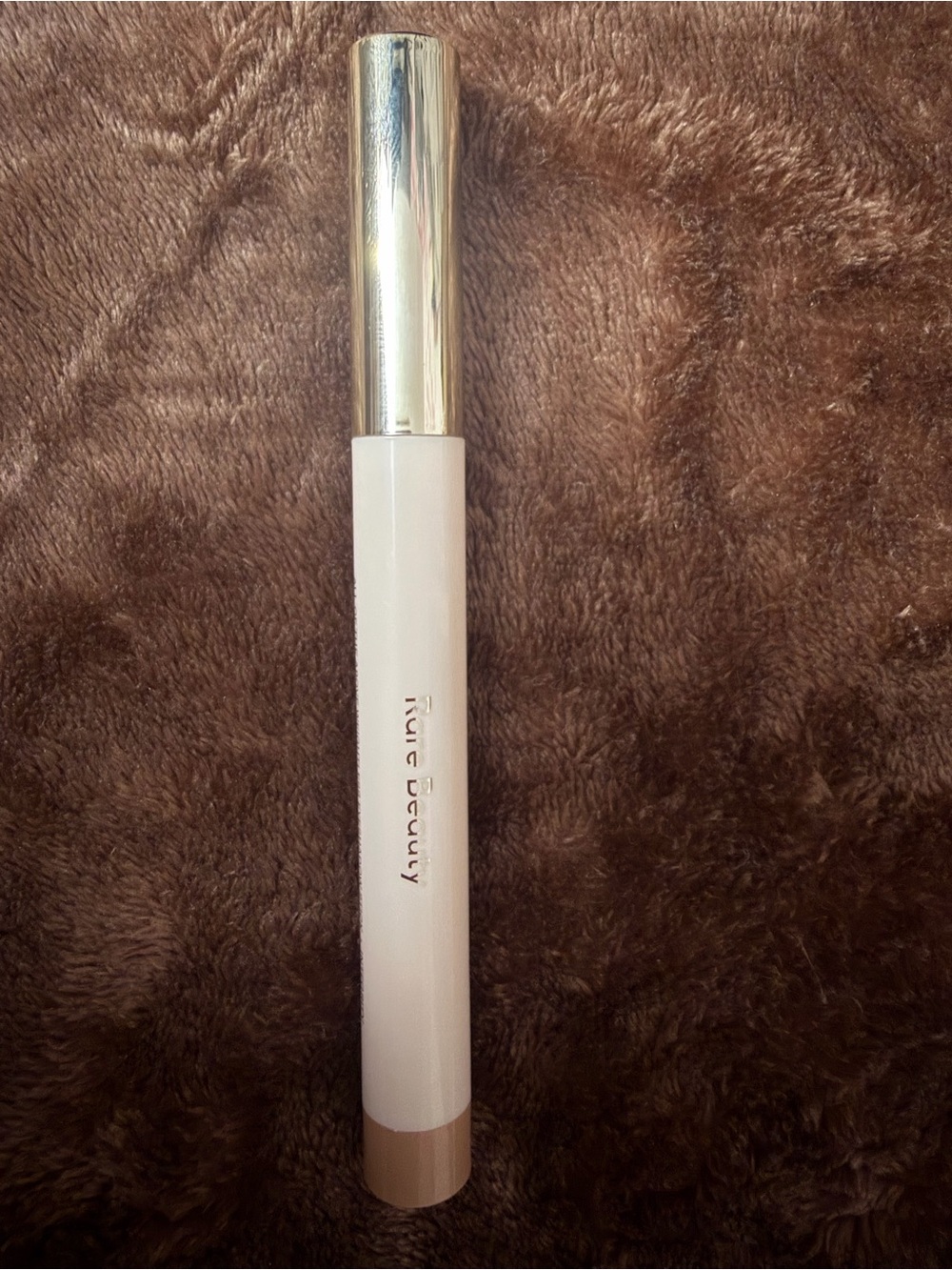 Rare Beauty eye cream stick in white, gold and beige